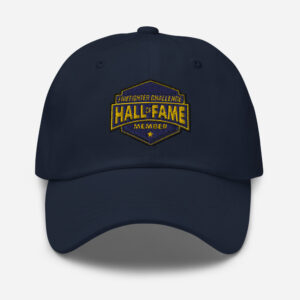 A navy cap featuring the Firefighter Challenge Hall of Fame Member logo embroidered in gold on the front, symbolizing membership in the Hall of Fame.