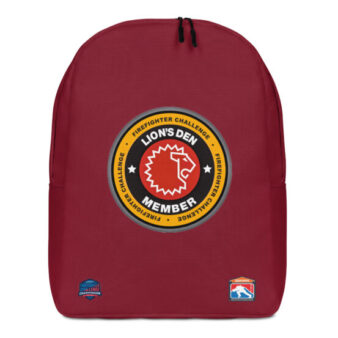 A red backpack with the Lion’s Den Member emblem in the center, featuring a lion’s head and the Firefighter Challenge logos near the bottom.