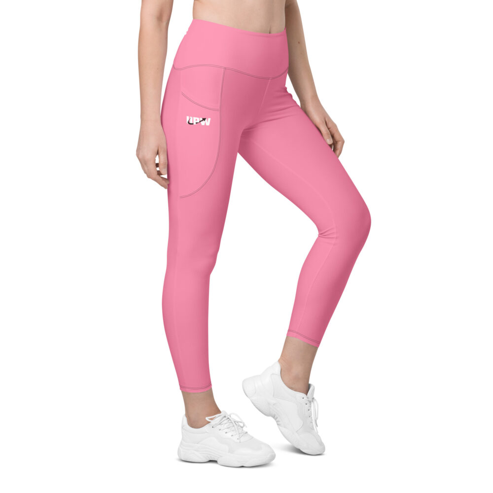 photo of the bottom half of a woman wearing pink leggings and white sneakers